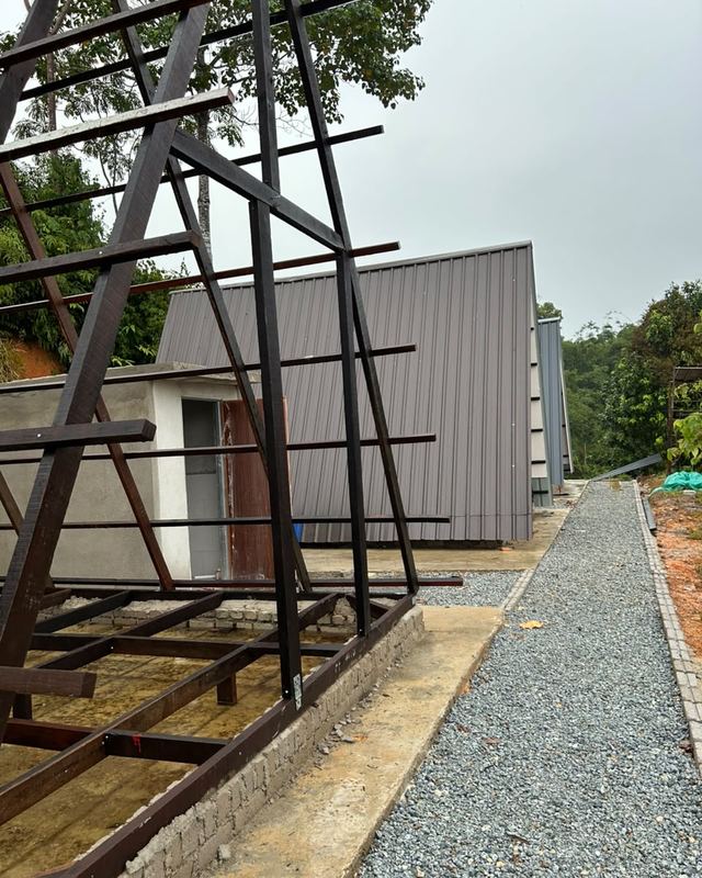 Rangka besi sebuah A-frame di sebelah A-frame yang dah siap