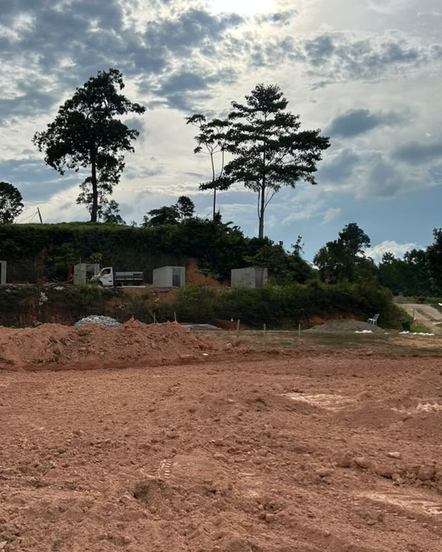 Tapak Sky Camp sebelum dibina: tanah merah yang baru diratakan, dengan dua pokok tinggi